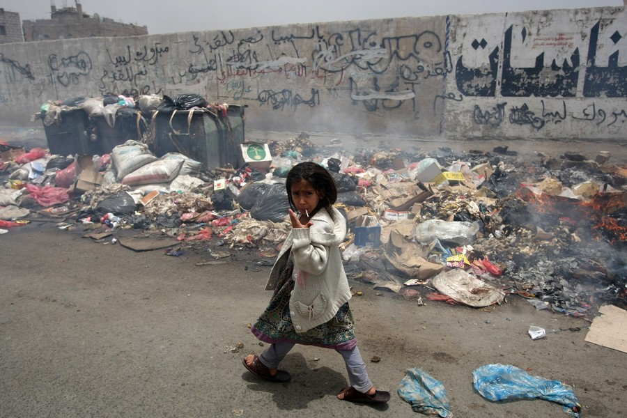 A Yemeni girl gestures as she walks past
