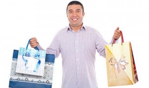 Buyer man holding shopping bags and smiling isolated on white background
