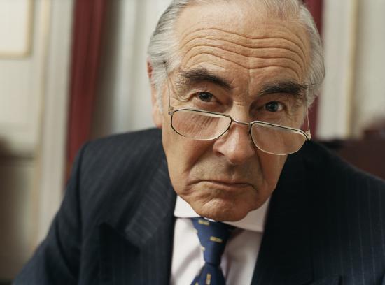 Portrait of a Sulking Businessman Wearing Spectacles and a Pinstripe Suit
